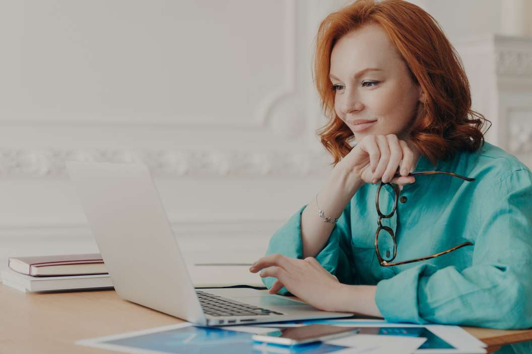 A woman using a laptop, symbolizing the process of retargeting potential premium MVA leads for a law firm's marketing efforts.